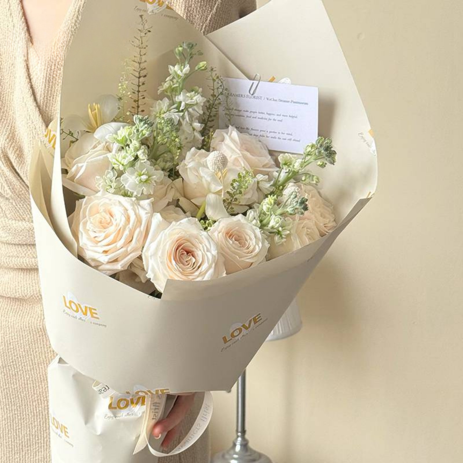 Buquê de flores claras em embalagem neutra